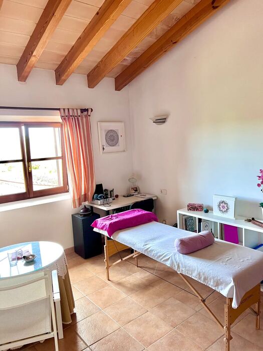 Dormitorio con vigas de madera vistas y ventana