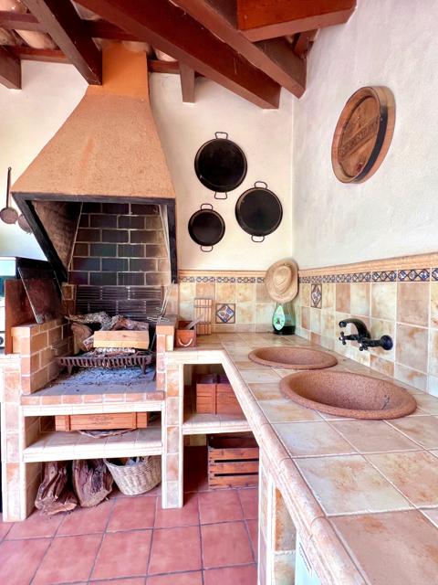 Zona de barbacoa con horno de leña y fregadero de piedra