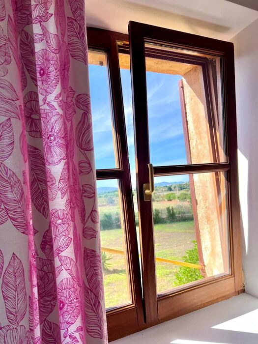 Ventana de madera con vistas al campo mallorquín